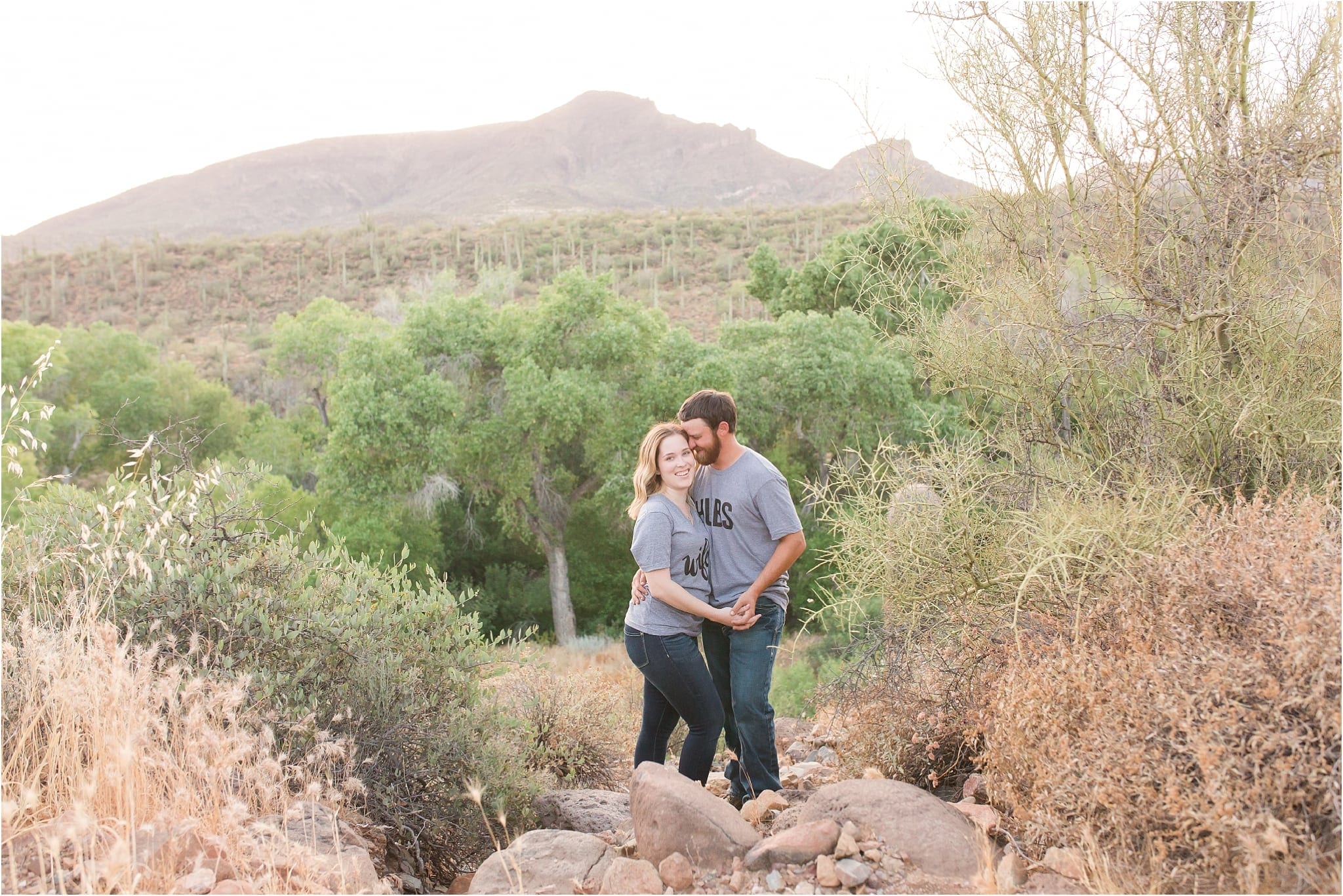 couple smiling with mountain and cactus in background
