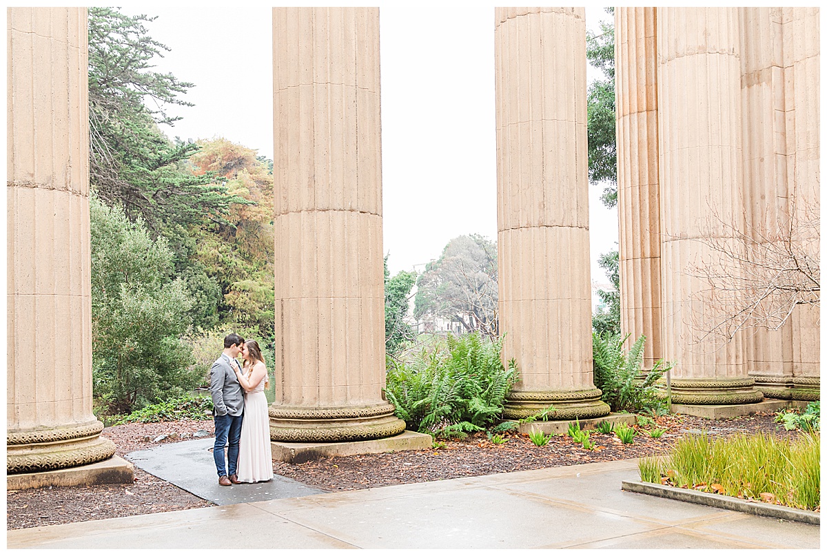 Couple holding on to each other by tall pillars