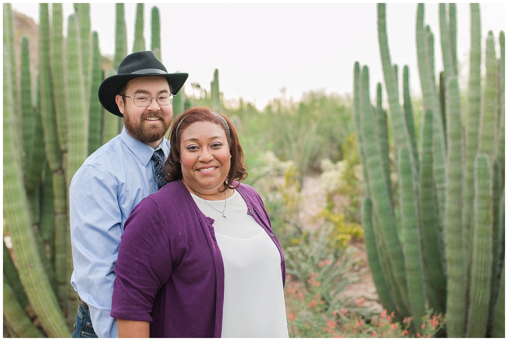 couple smiling with cactus behind them