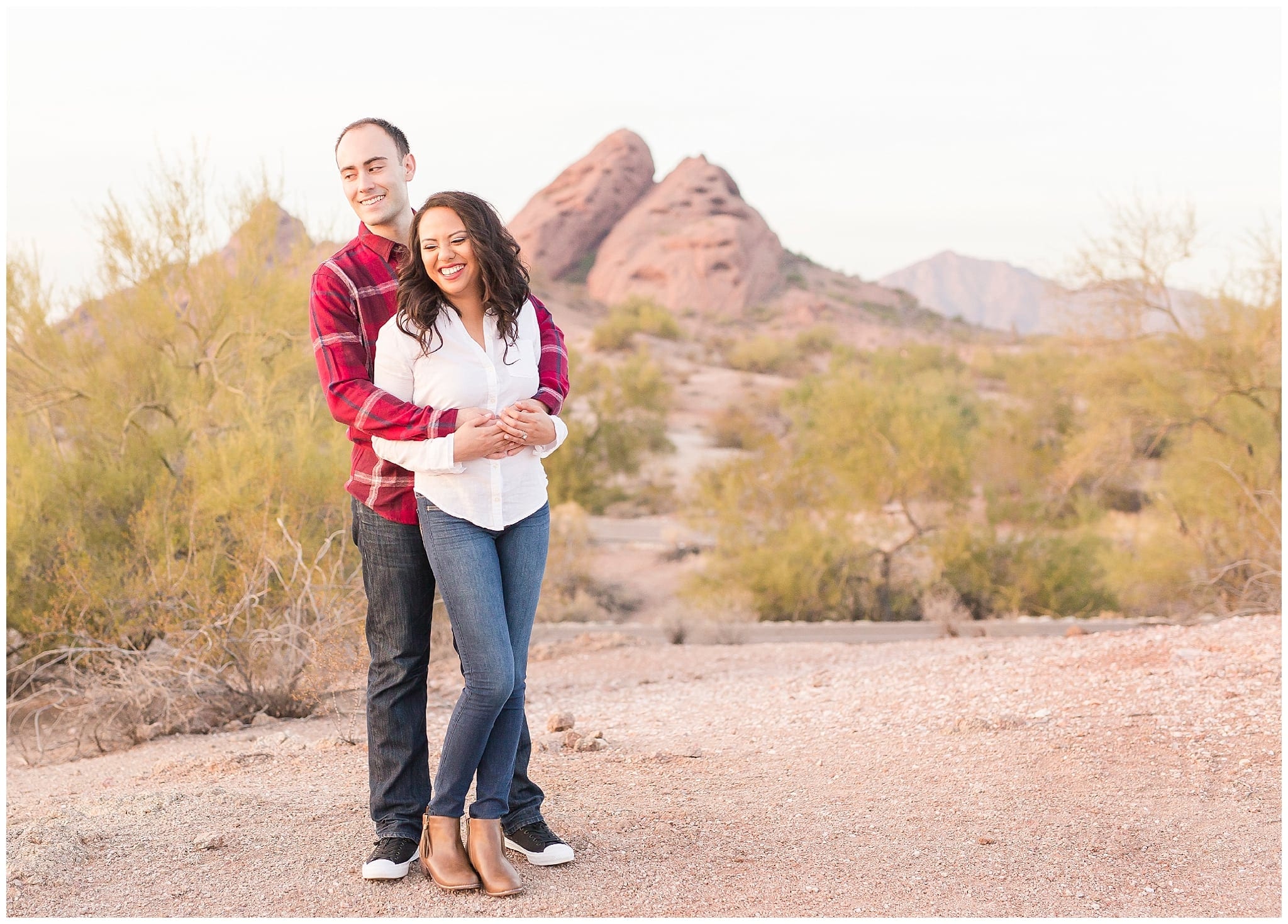 Couple kissing at Papago Park, Red rocks, white shirt, blue jeans, red plaid shirt