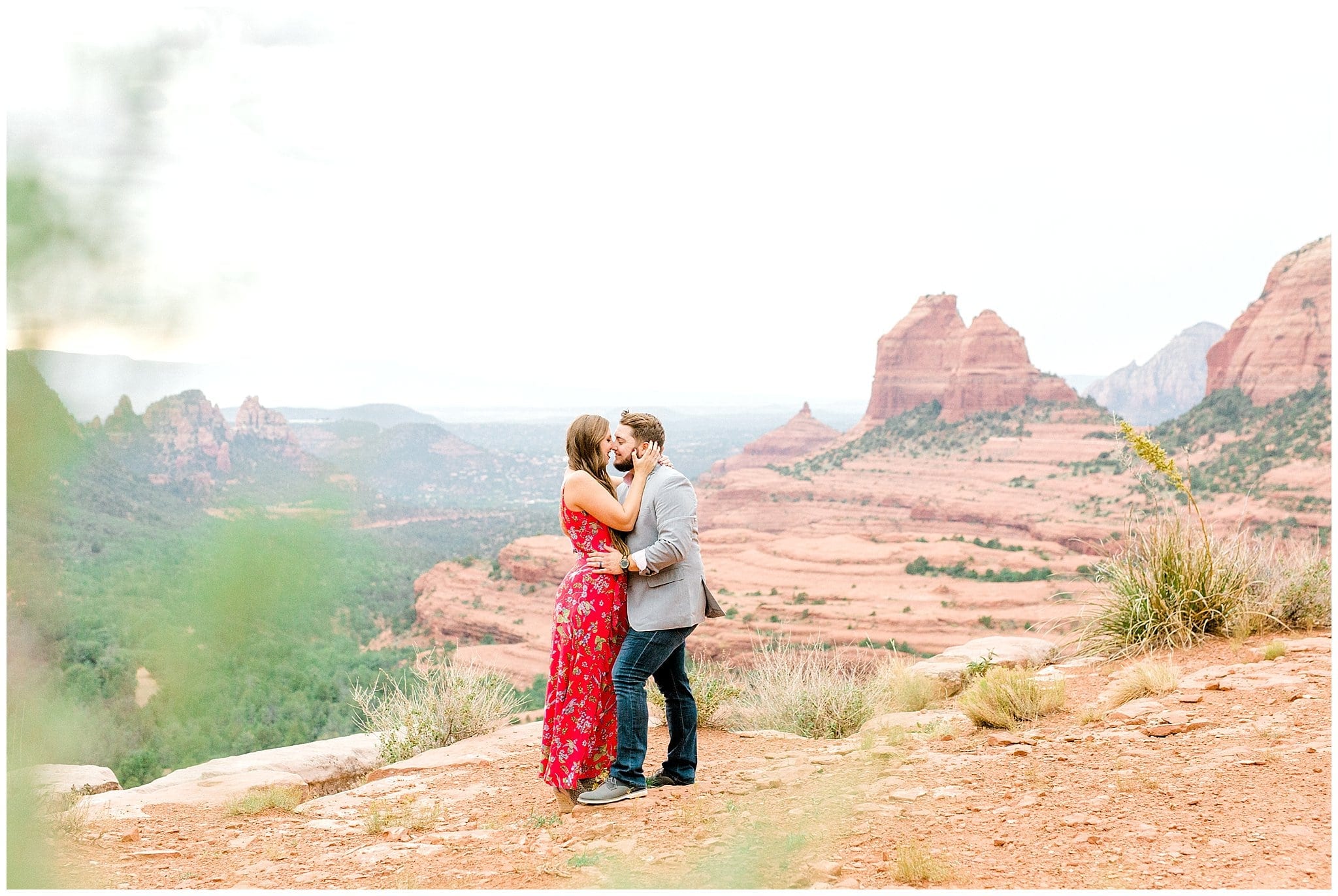 couple kissing with red rock behind them