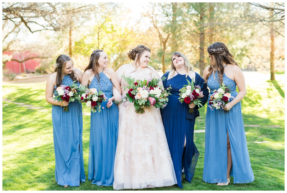 bridesmaids walking in grass, navy and light blue dresses