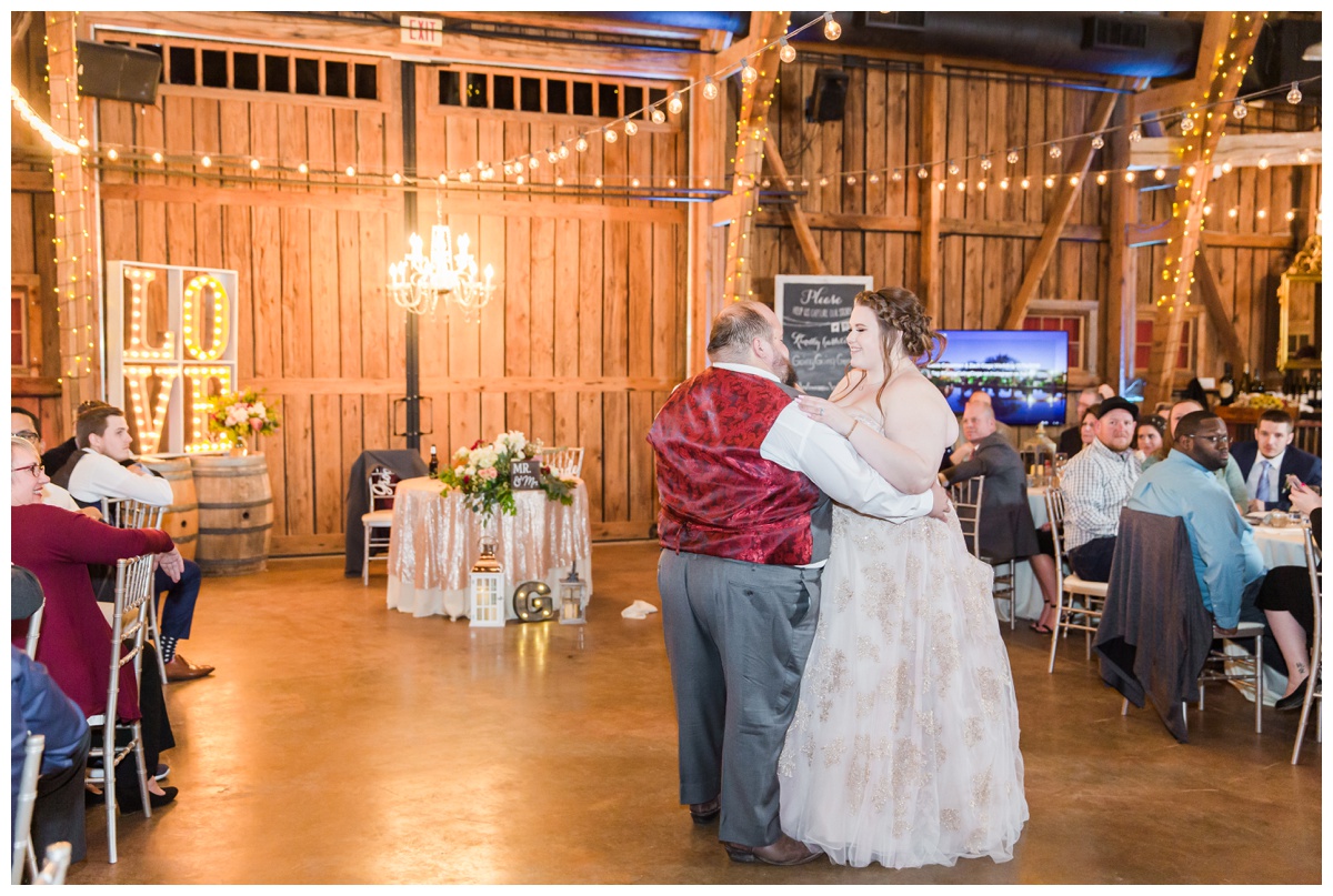 Bride and Groom slow dance inside barn