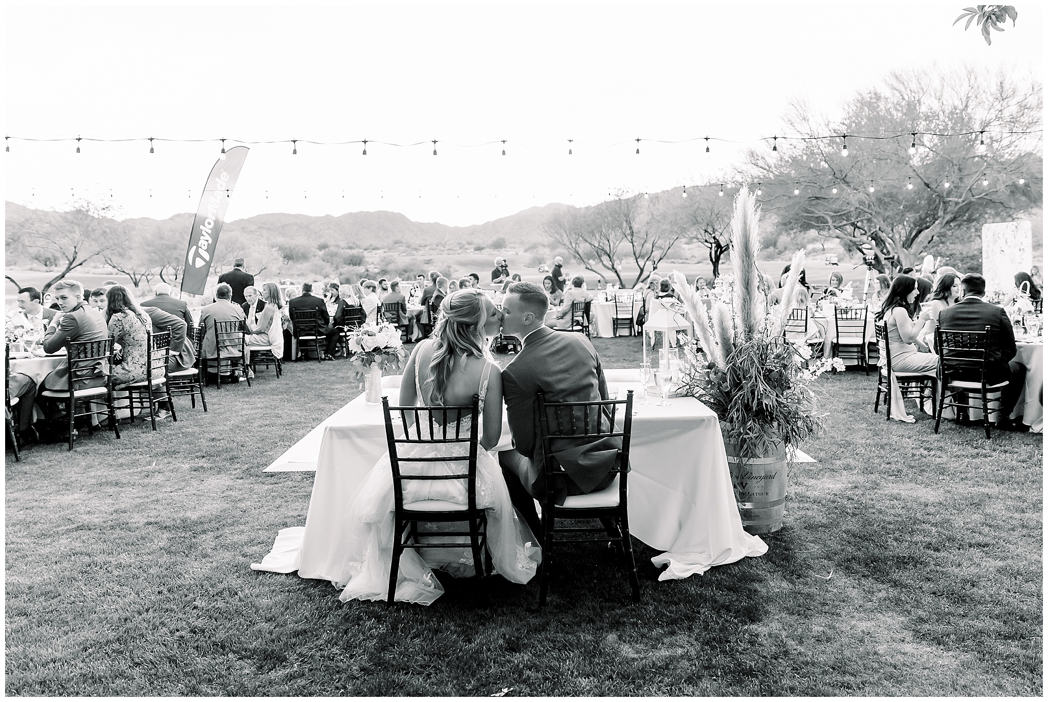 Bride and Groom Kissing at Reception Table