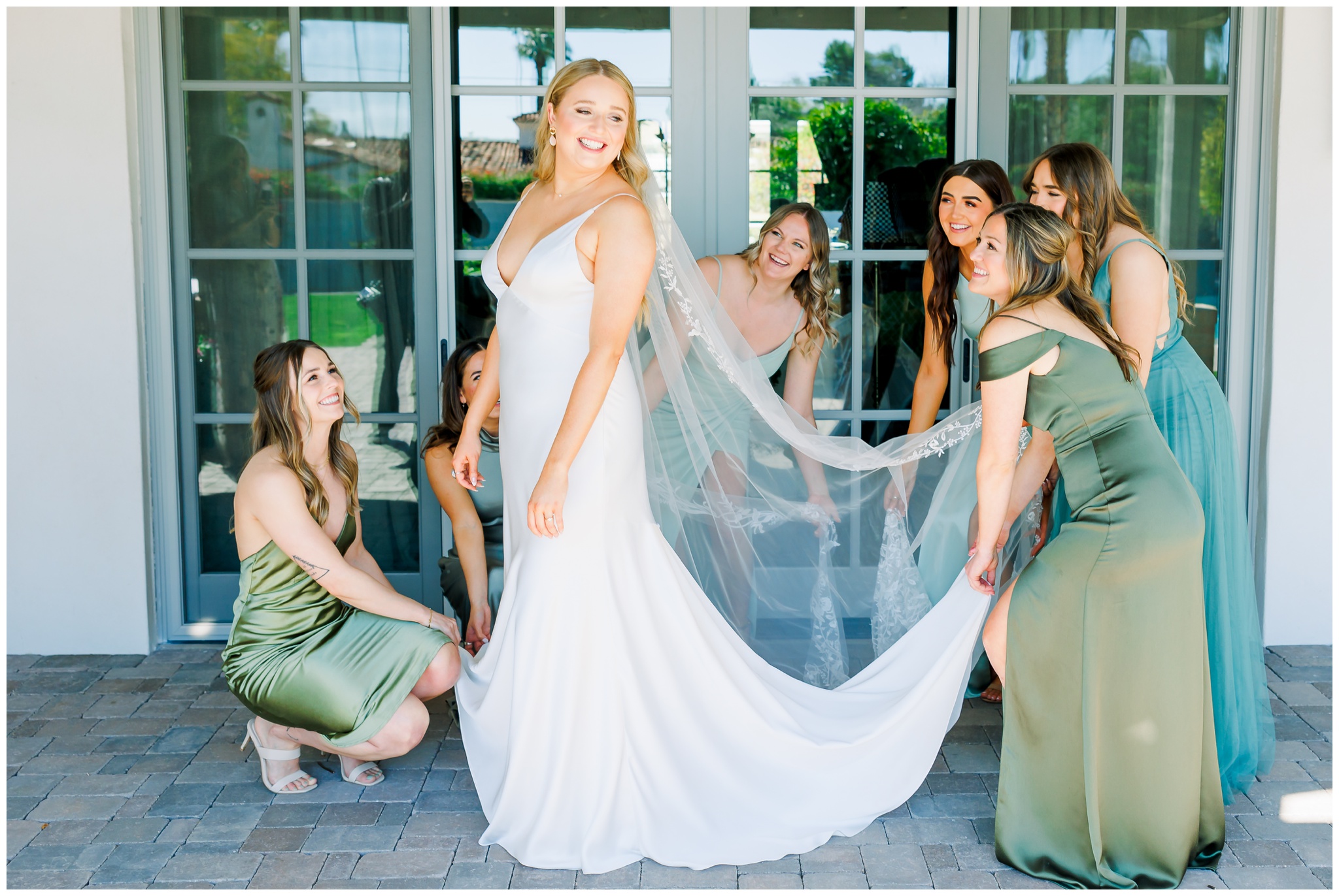 bridesmaids helping bride get dressed