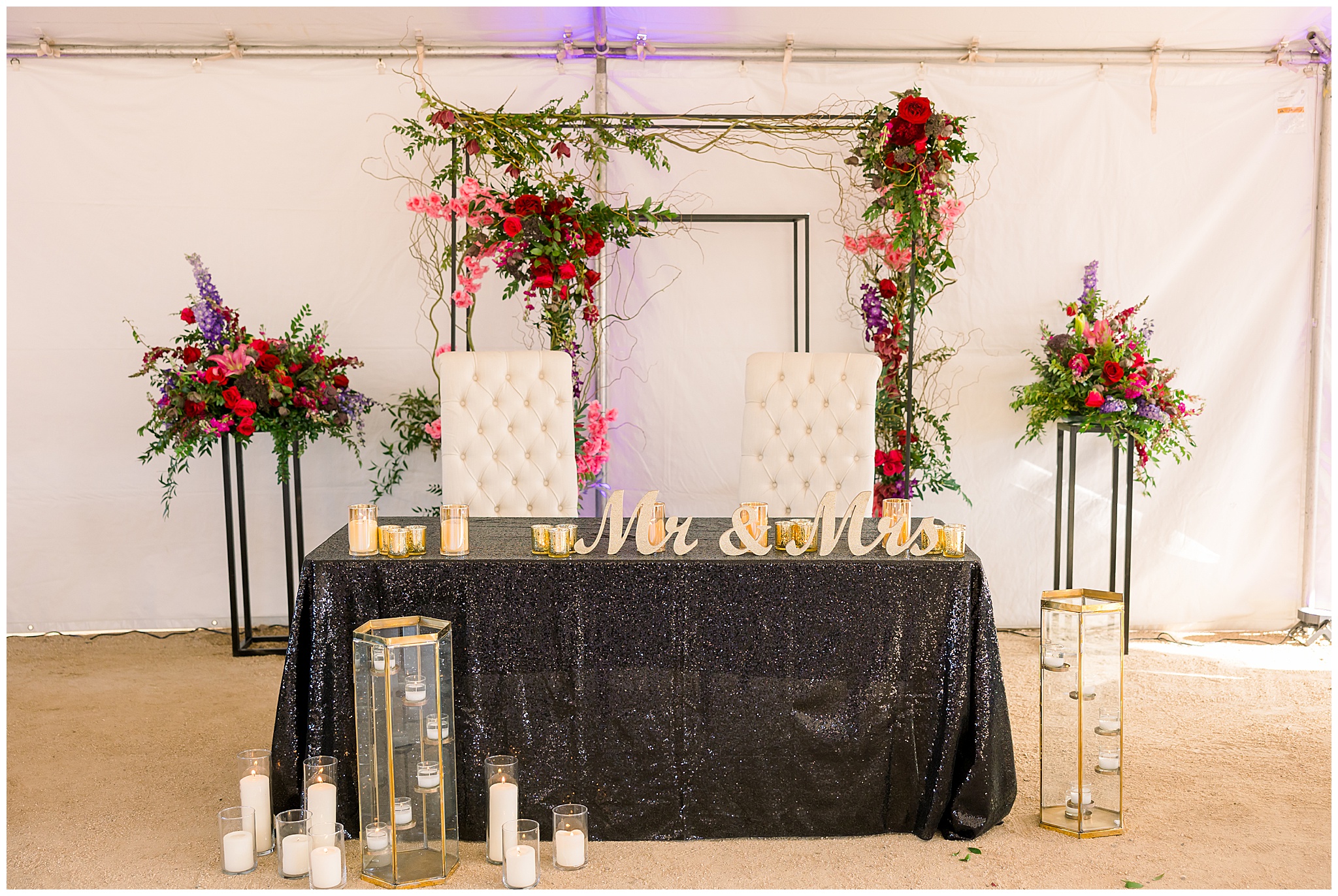 head table with candles and pink, purple and red flowers