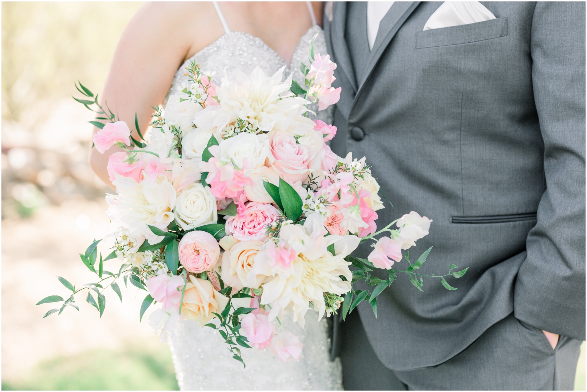 Bride and groom holding blush and white bouquet